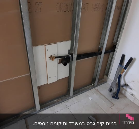 קיר גבס עם מסגרת מתכת וצינור שחור